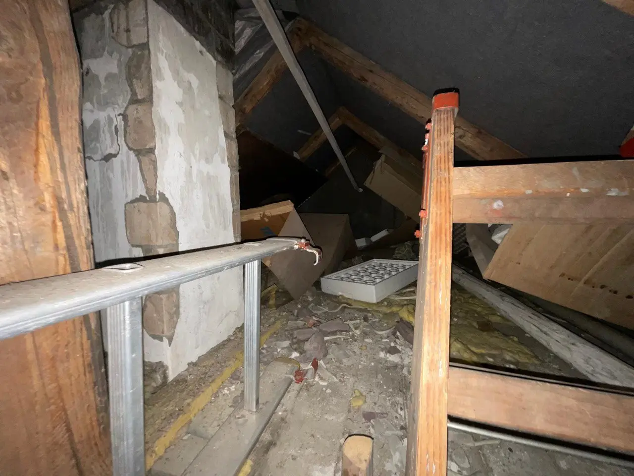 Dachboden mit Holzbalken und abgestellten Gegenständen, die noch gesichtet werden