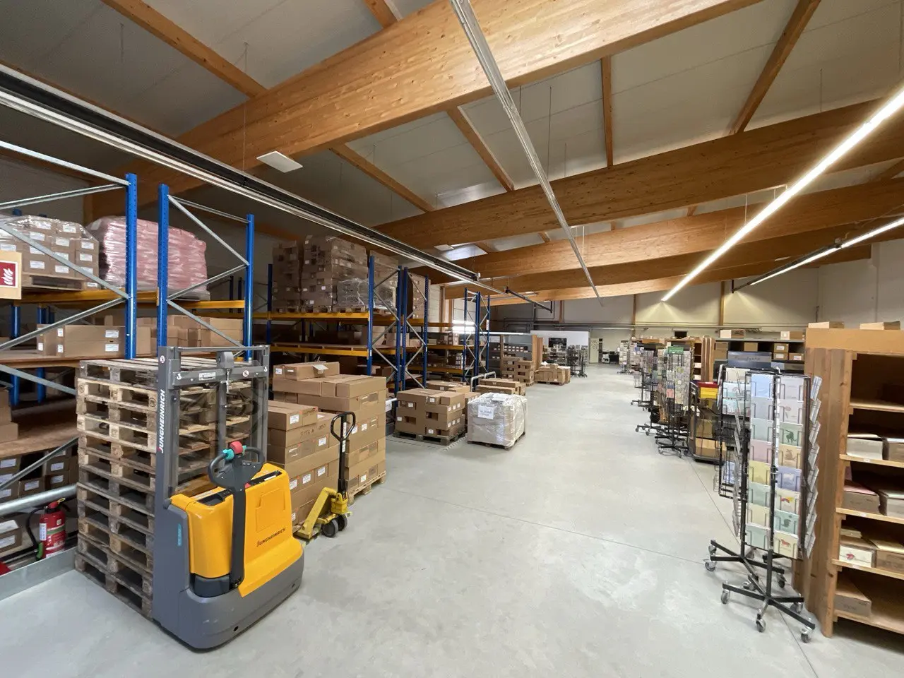 Lagerhalle mit Regalen, Kartons und Hubwagen bei einer Räumung