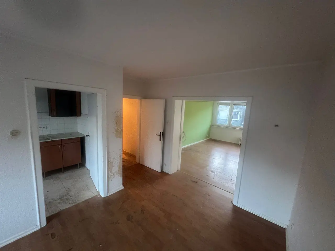 Leere Wohnung mit Blick durch offene Türen in Flur und Küche